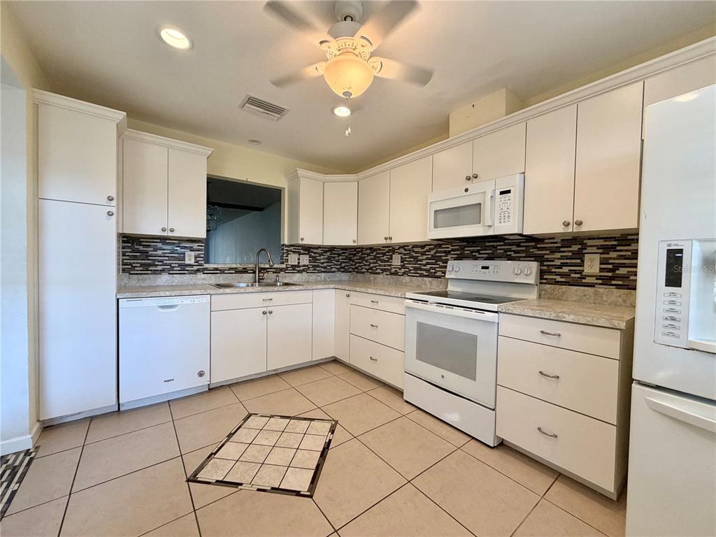11210 Dollar Lake Drive, Unit 2 Port Richey, FL 34668 - Photo 5 of 15 a kitchen with cabinets stainless steel appliances and a window