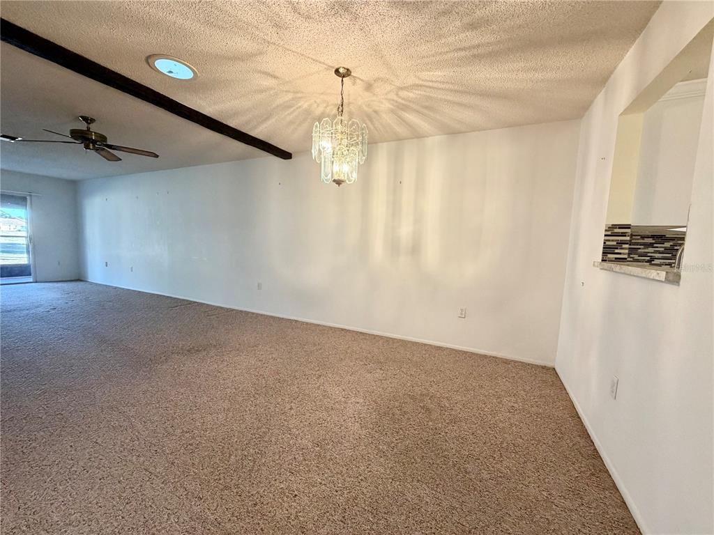 11210 Dollar Lake Drive, Unit 2 Port Richey, FL 34668 - Photo 6 of 15 an empty room with windows and ceiling fan