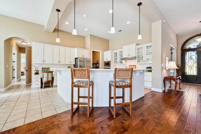 a living room with stainless steel appliances kitchen island granite countertop furniture wooden floor and a kitchen view