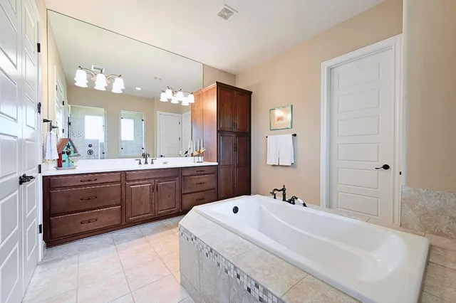 a spacious bedroom with a bed and a chandelier