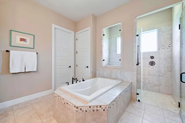 a spacious bathroom with a tub sink and mirror