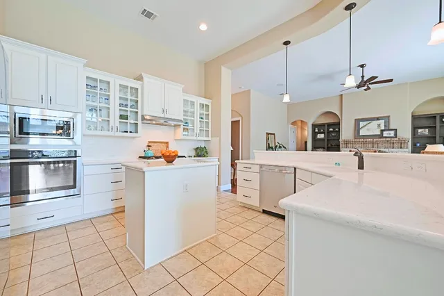 a kitchen with white cabinets and stainless steel appliances