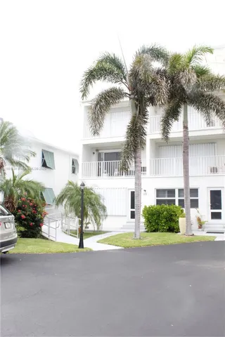 front view of house with a yard and potted plants