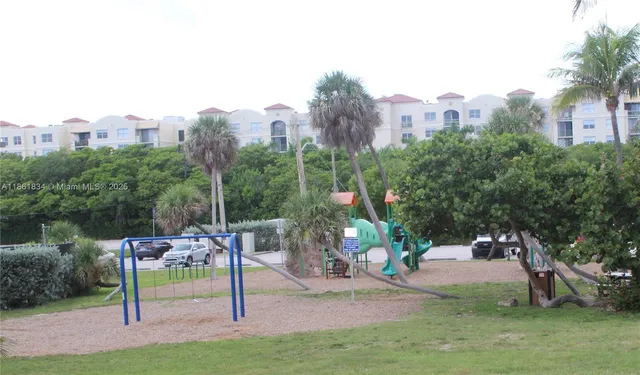 a view of a backyard with sitting area and tree
