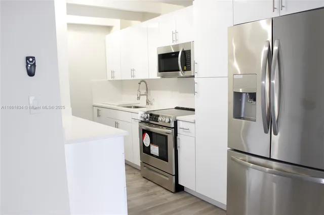 a kitchen with stainless steel appliances a refrigerator microwave and sink