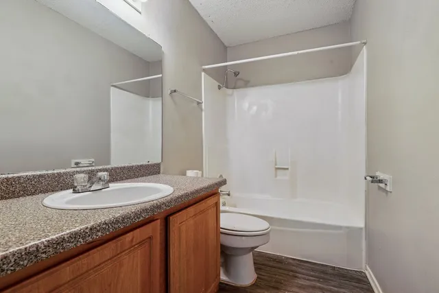 a bathroom with a granite countertop sink toilet and shower