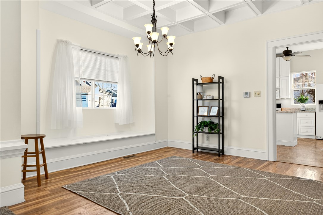 107 Riverside Drive Piqua, OH 45356 - Photo 9 of 69 This inviting room features warm wood flooring, a window bench, and an elegant chandelier.