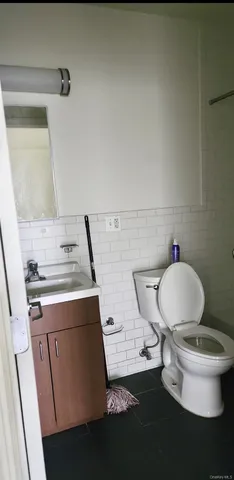 a bathroom with a granite countertop toilet sink and mirror