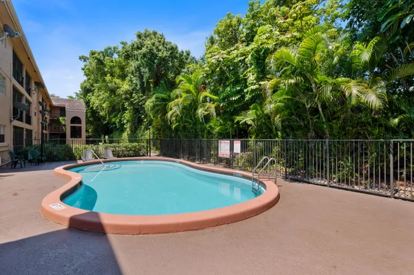 a view of a swimming pool with a yard and sitting area