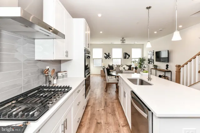 a kitchen with kitchen island granite countertop lots of counter top space a sink stainless steel appliances and cabinets
