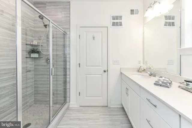 a bathroom with a shower sink and mirror