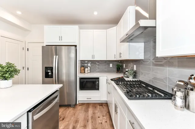a kitchen with stainless steel appliances a sink a stove a refrigerator and cabinets