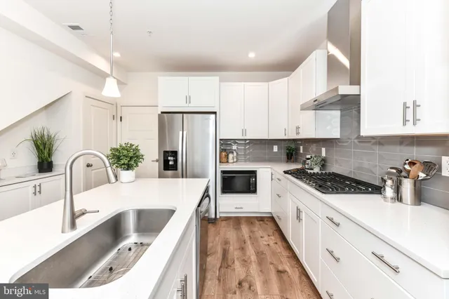 a kitchen with white cabinets sink and white appliances