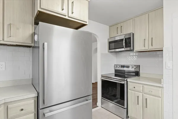 a kitchen with white cabinets and stainless steel appliances