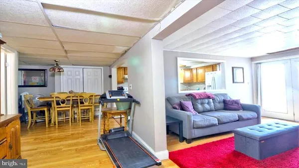 a living room with furniture a wooden floor and next to a window