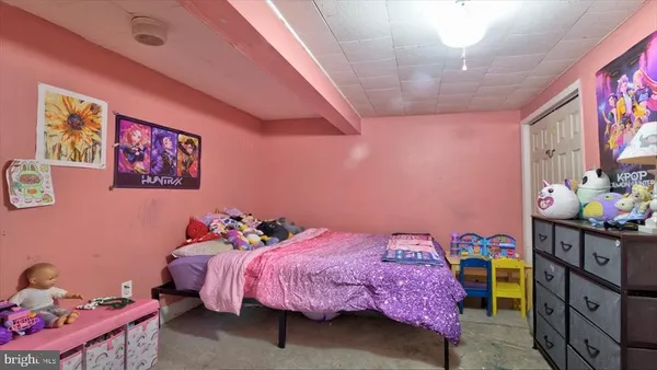 a soft toy sitting on a bed in a pink room