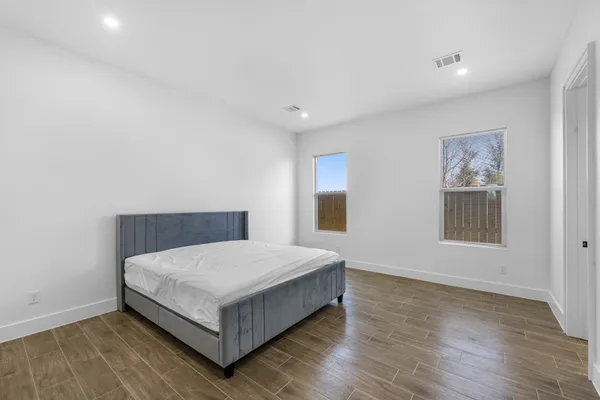 a room with a bed and wooden floor