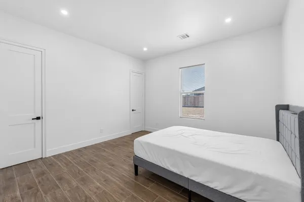 a bedroom with a bed and wooden floor