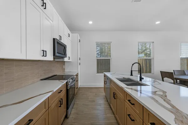 a kitchen with stainless steel appliances granite countertop a sink stove and microwave