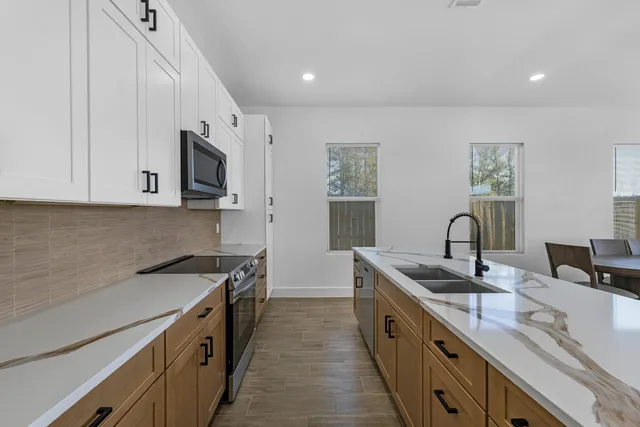 a kitchen with stainless steel appliances granite countertop a sink stove and microwave