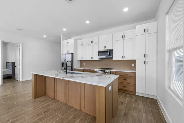 a kitchen with stainless steel appliances a sink stove and cabinets