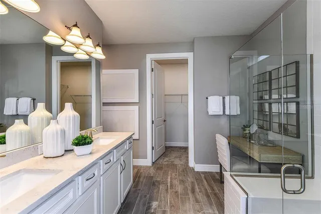 a spacious bathroom with a granite countertop sink a mirror and a shower