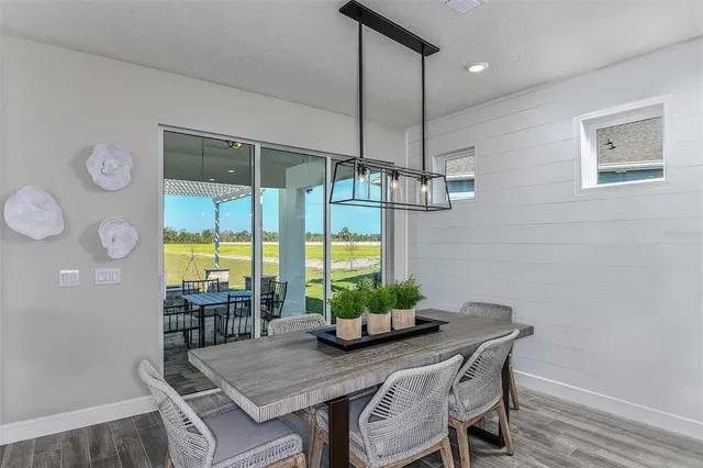 a dining room with furniture a chandelier and wooden floor