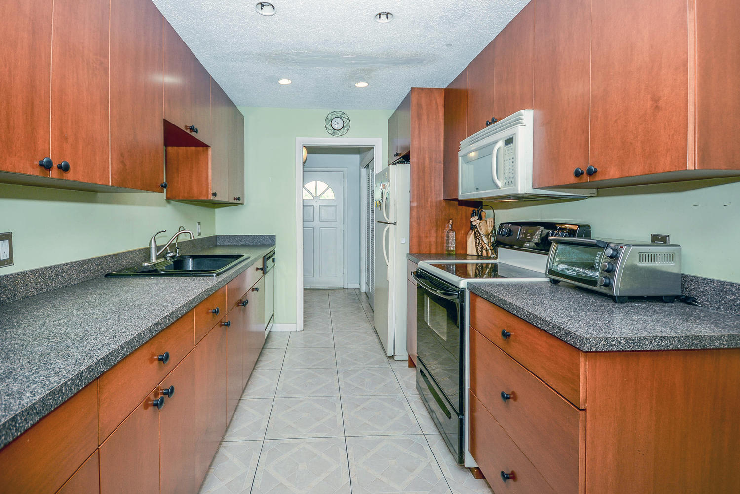 493 Dover Road Tequesta, FL 33469 - Photo 20 of 33 a kitchen with stainless steel appliances granite countertop a sink stove and cabinets