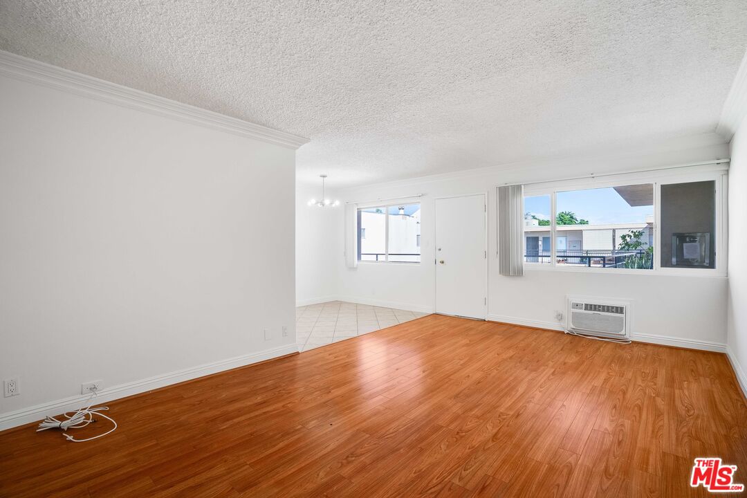 7548 Hampton Avenue, Unit 304 West Hollywood, CA 90046 - Photo 1 of 23 an empty room with wooden floor and windows
