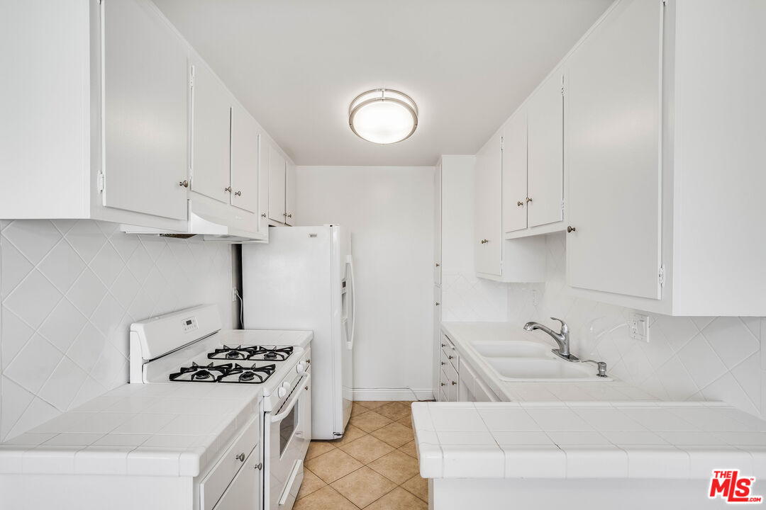 7548 Hampton Avenue, Unit 304 West Hollywood, CA 90046 - Photo 5 of 23 a bathroom with a sink a stove and a refrigerator