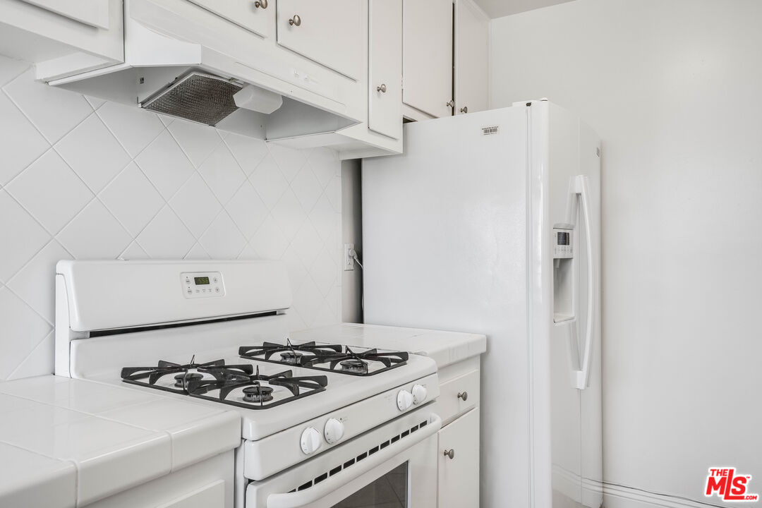 7548 Hampton Avenue, Unit 304 West Hollywood, CA 90046 - Photo 7 of 23 a kitchen with a stove and a refrigerator