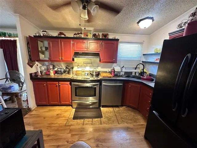 a kitchen with a sink appliances and cabinets