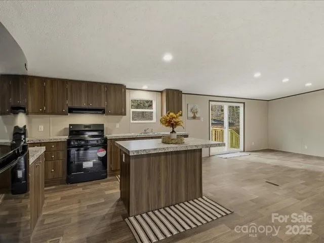 a kitchen with stainless steel appliances granite countertop a stove a sink and a refrigerator