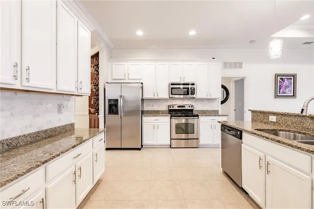 a kitchen with stainless steel appliances granite countertop a refrigerator and a stove top oven