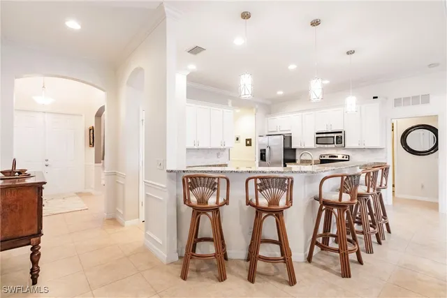 a kitchen with stainless steel appliances kitchen island granite countertop a table and chairs in it