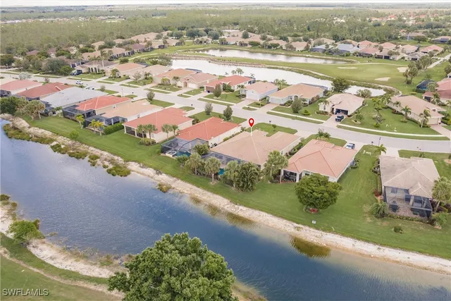 an aerial view of lake and residential houses with outdoor space