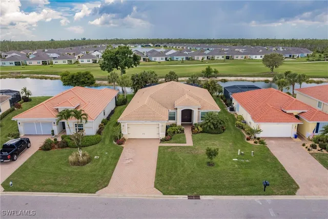 an aerial view of a house with outdoor space lake view and a large tree