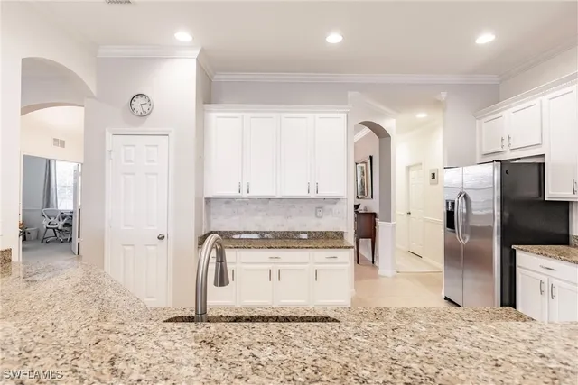 a kitchen with stainless steel appliances granite countertop a refrigerator a stove and a sink