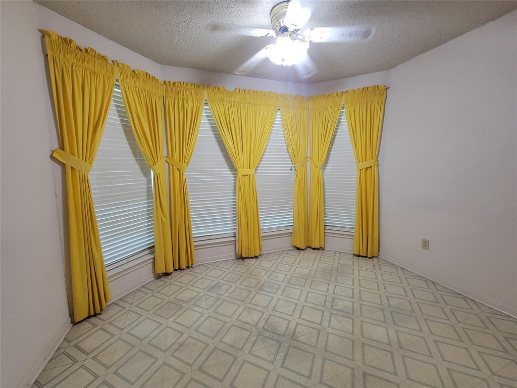 630 Country View Lane Garland, TX 75043 - Photo 11 of 29 Breakfast area with bay windows with blinds and yellow curtains, a ceiling fan with integrated lighting, and patterned flooring