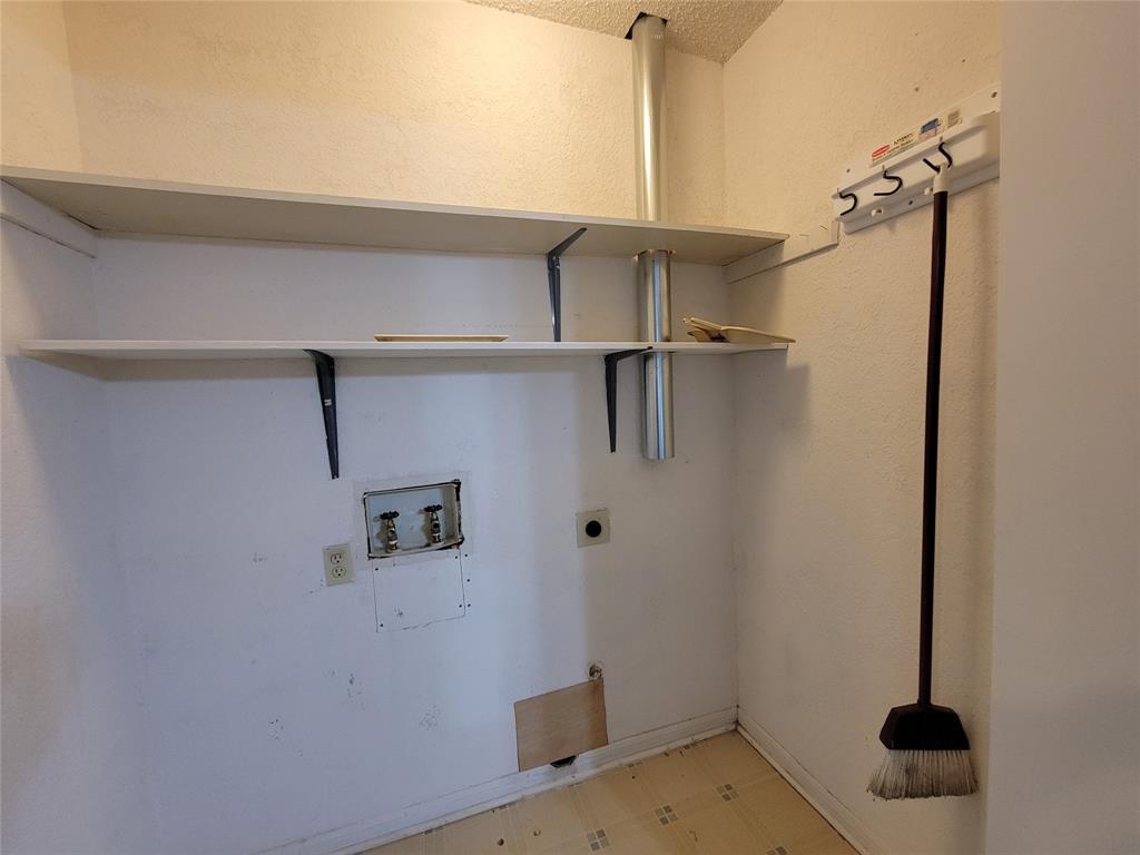 630 Country View Lane Garland, TX 75043 - Photo 23 of 29 Utility closet featuring built-in shelving, plumbing rough-ins, electrical outlet, and vinyl flooring