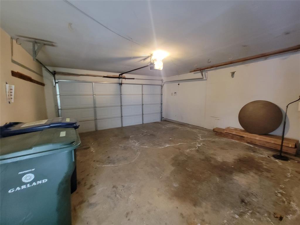 630 Country View Lane Garland, TX 75043 - Photo 25 of 29 Spacious garage with a white sectional door, concrete flooring, and overhead lighting