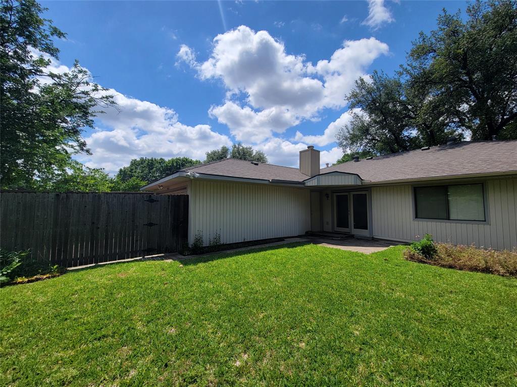 630 Country View Lane Garland, TX 75043 - Photo 28 of 29 Expansive lawn area featuring a privacy fence, concrete patio, and a light-colored stucco exterior