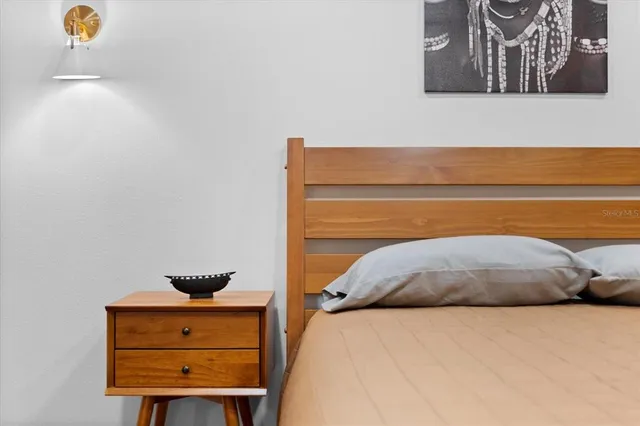 a bedroom with a bed and teddy bear on bed