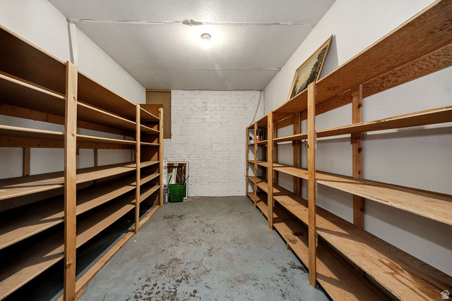 299 West Center Street, Unit 2 Logan, UT 84321 - Photo 30 of 46 Dedicated storage room featuring extensive wood shelving, a painted concrete floor, and painted white brick wall