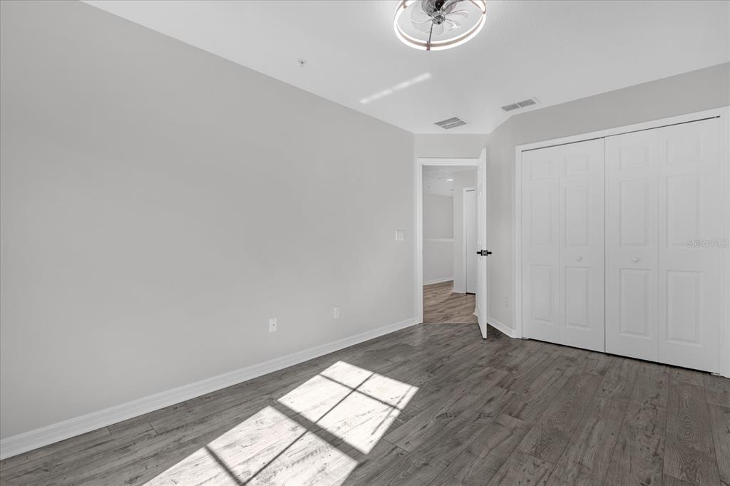 9450 Silver Buttonwood Street Orlando, FL 32832 - Photo 18 of 25 an empty room with wooden floor and windows