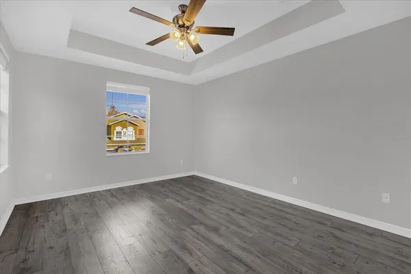 an empty room with a window and ceiling fan