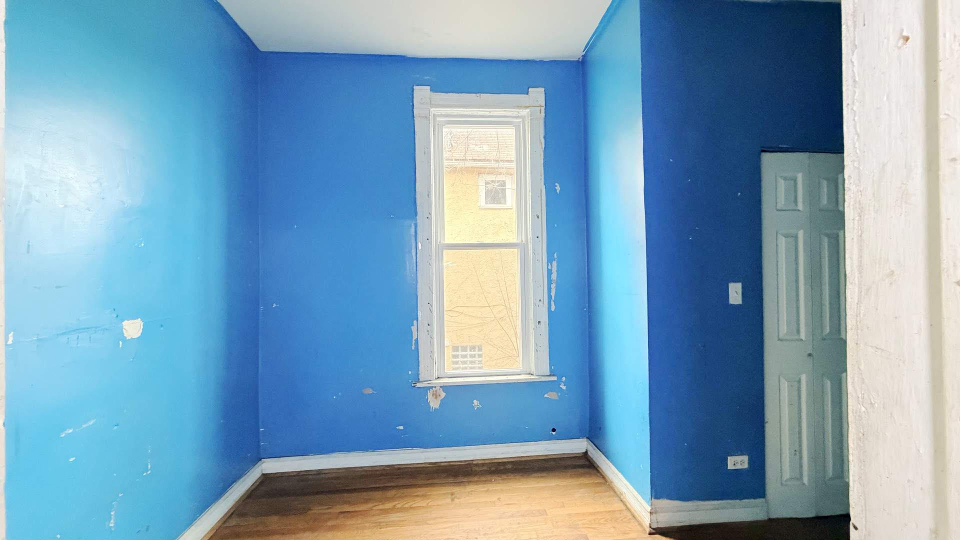 7704 South Ada Street Chicago, IL 60620 - Photo 9 of 10 a view of an empty room with wooden floor and a window
