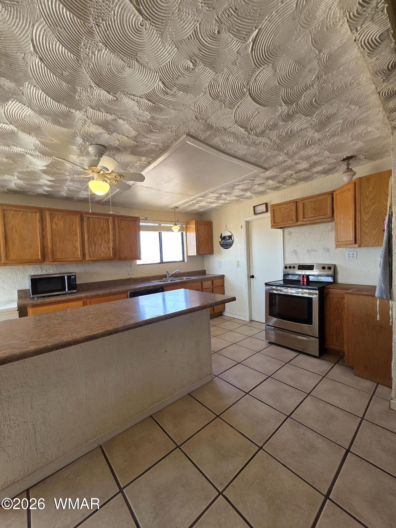 80 L K Ranch Road Holbrook, AZ 86025 - Photo 16 of 29 a kitchen with stainless steel appliances kitchen island granite countertop a sink and cabinets