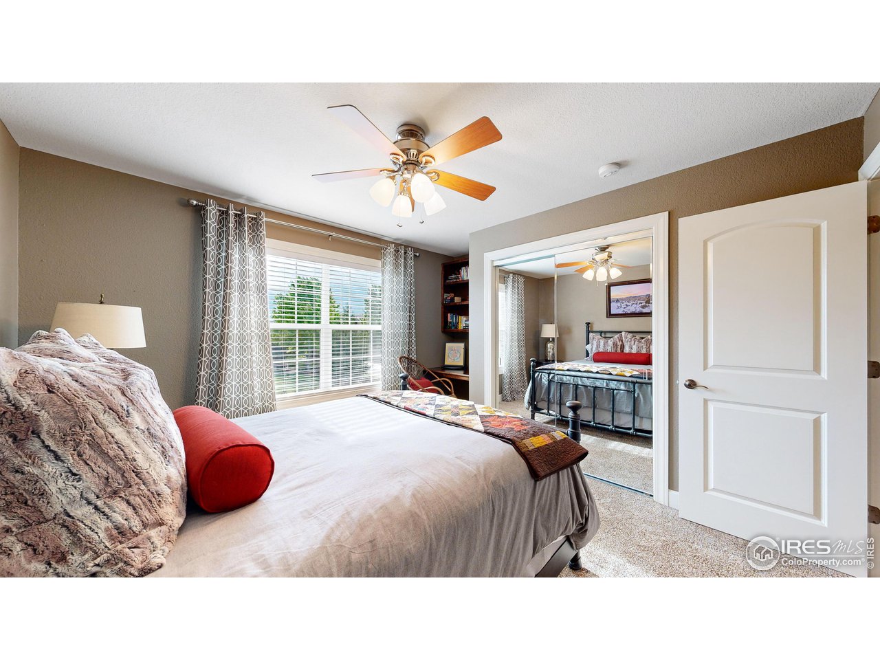 8398 Spinnaker Bay Drive Windsor, CO 80528 - Photo 19 of 40 a bedroom with a bed a dresser and a large window
