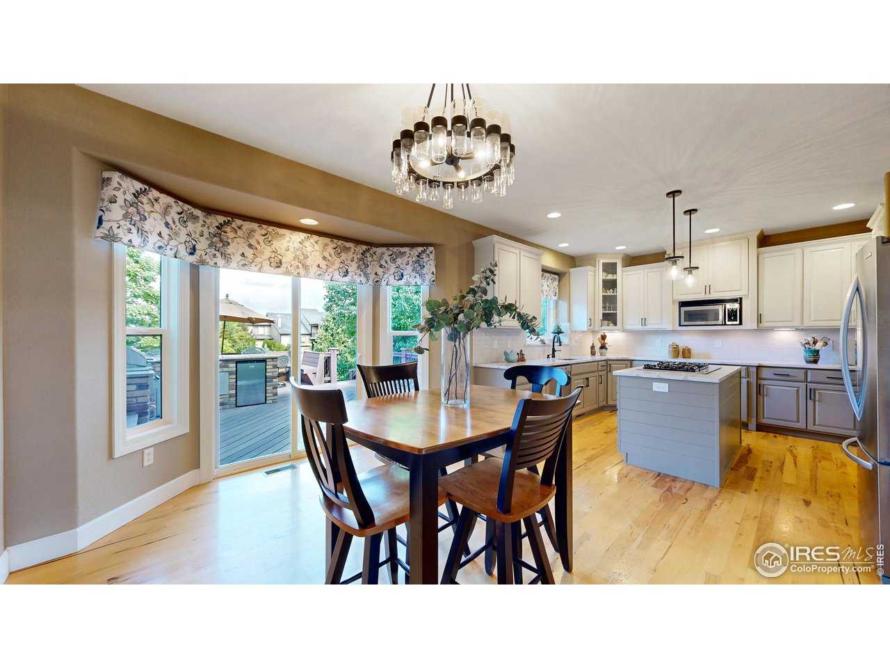 8398 Spinnaker Bay Drive Windsor, CO 80528 - Photo 7 of 40 a kitchen with stainless steel appliances granite countertop a dining table chairs and a large window